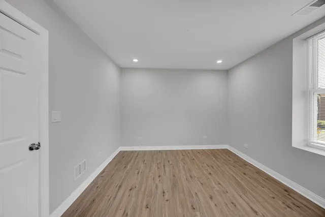 a view of room with window and wooden floor