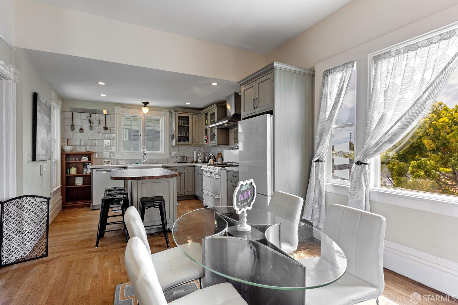 1918 Broadway Alameda, CA 94501 - Photo 14 of 28 a kitchen with stainless steel appliances granite countertop a table chairs and a refrigerator