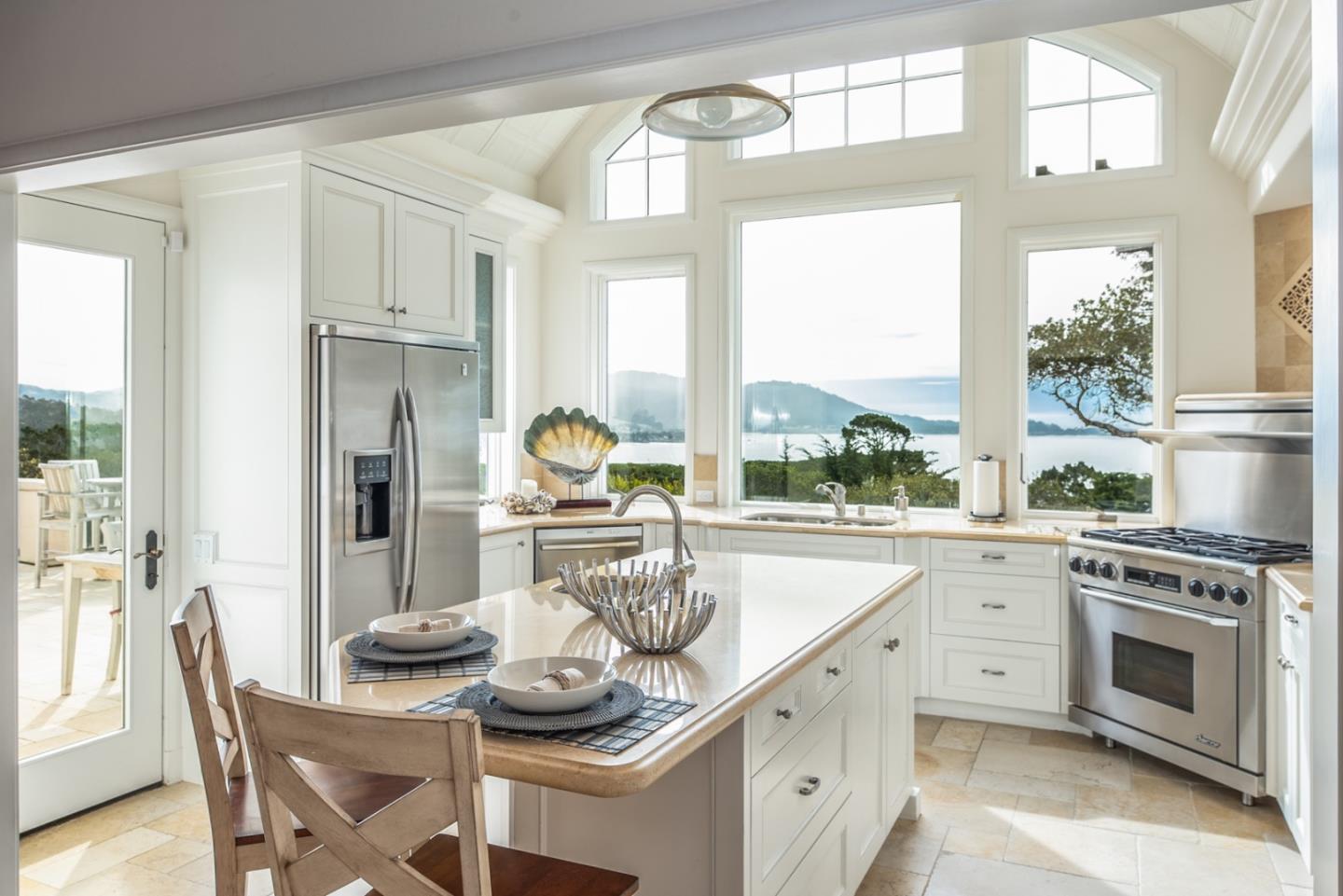 1465 Oleada Road Pebble Beach, CA 93953 - Photo 9 of 30 a kitchen with a stove a sink and a dining table
