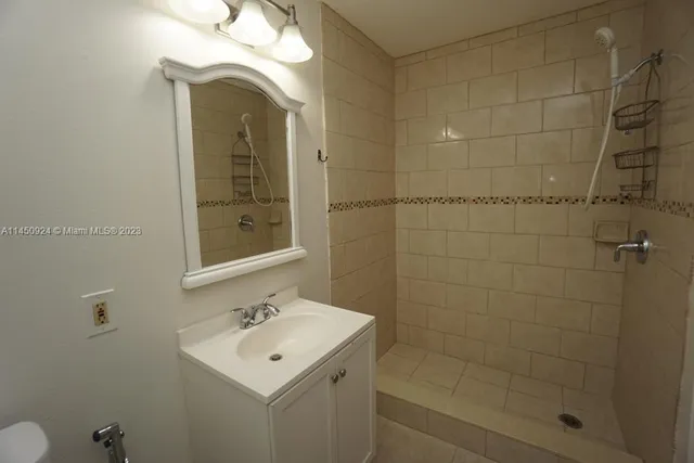 a bathroom with a sink mirror and shower