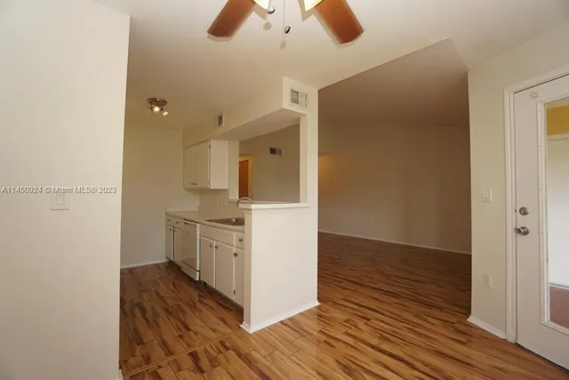 a kitchen with cabinets and wooden floor