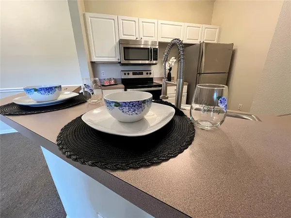 a kitchen with stainless steel appliances granite countertop a stove a microwave and cabinets