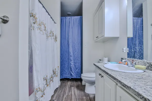 a bathroom with a granite countertop double vanity sink a mirror and shower