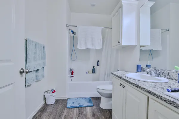 a bathroom with a granite countertop toilet sink and mirror