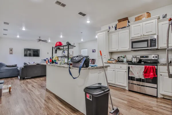 a kitchen with stainless steel appliances kitchen island granite countertop a stove and cabinets