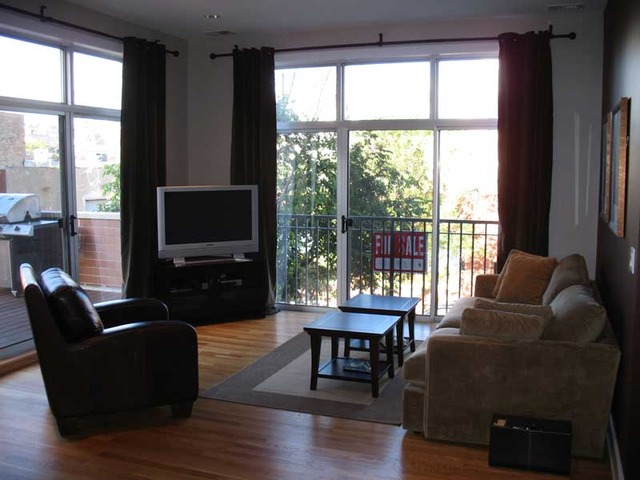 6 North May Street, Unit 201 Chicago, IL 60607 - Photo 3 of 10 a living room with furniture a flat screen tv and a floor to ceiling window