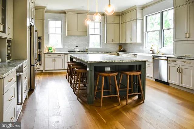 a kitchen with stainless steel appliances granite countertop a stove a sink and a refrigerator