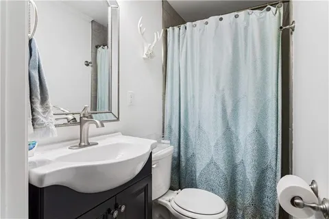 a bathroom with a sink a toilet and shower curtain