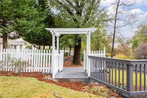 a view of a house with wooden fence next to a road