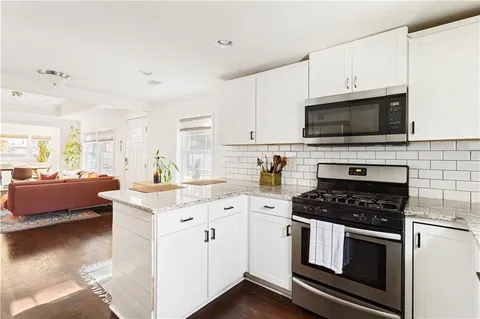 a kitchen with granite countertop a sink a stove and cabinets
