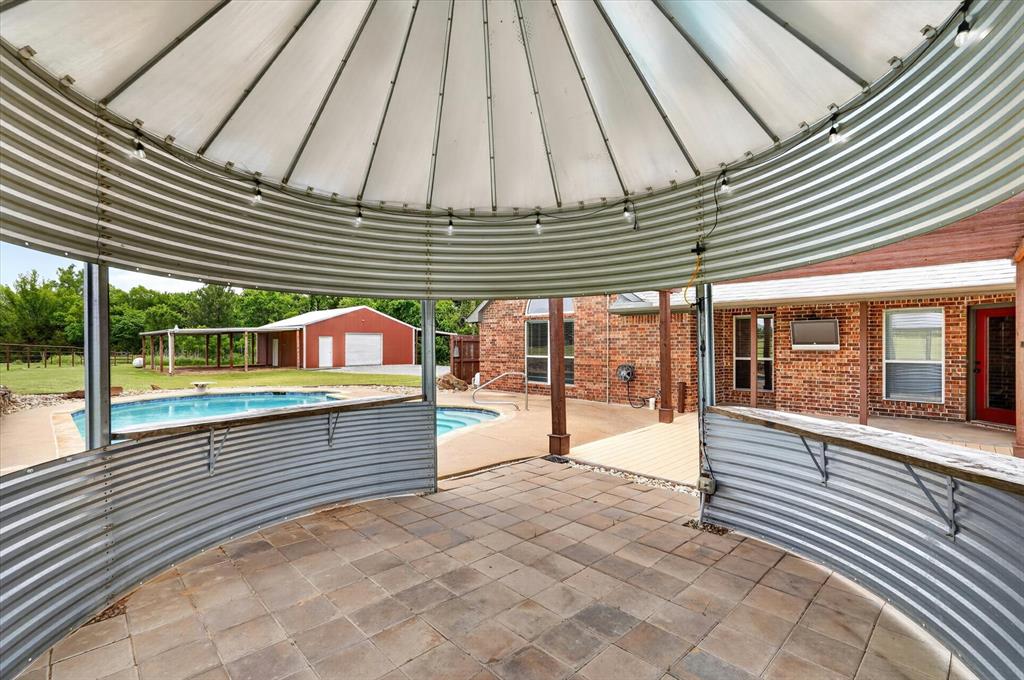 2828 Bennett Road Howe, TX 75459 - Photo 34 of 39 a view of a patio with a table and chairs under an umbrella
