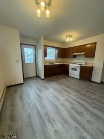 a living room with stainless steel appliances furniture window and wooden floor