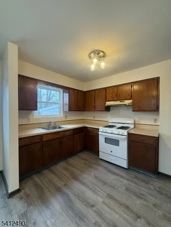 a large kitchen with stainless steel appliances and wooden cabinets