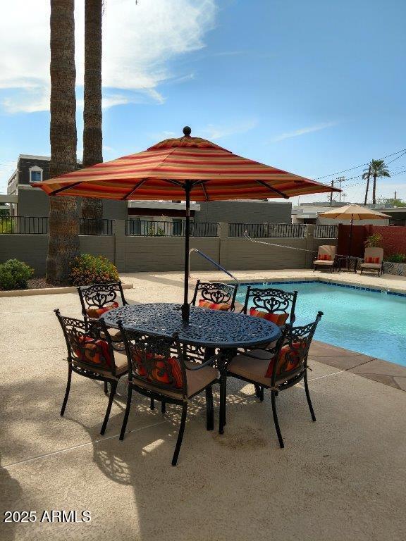 4419 North 27th Street, Unit 2 Phoenix, AZ 85016 - Photo 25 of 37 a view of a patio with table and chairs under an umbrella with a fire pit