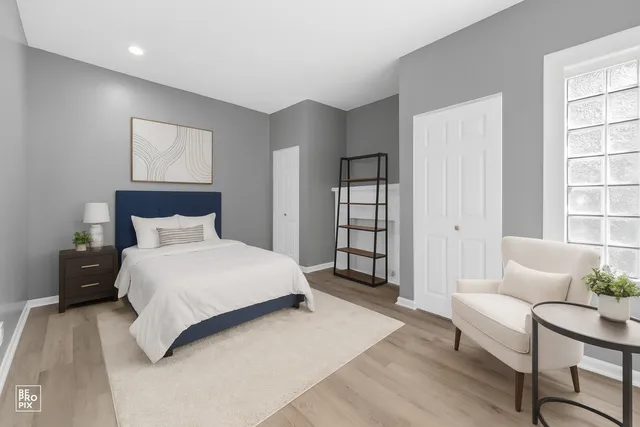 a spacious bedroom with a bed a couch and windows