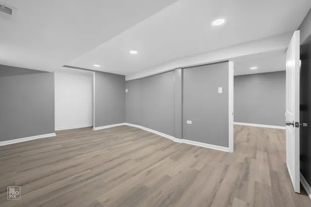 a view of an empty room with wooden floor