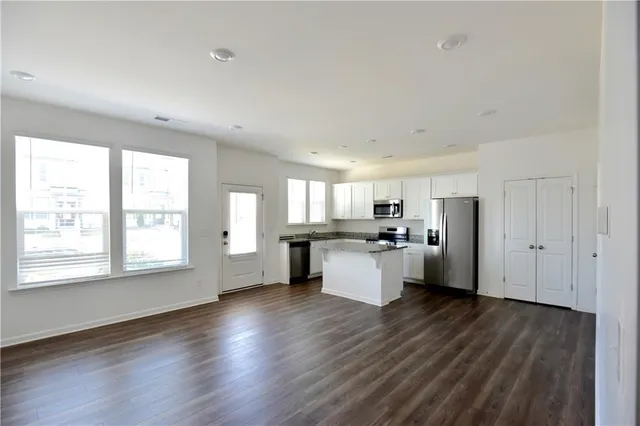 a kitchen with kitchen island wooden floors and white walls