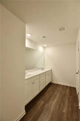 a room with a sink cabinets and wooden floor