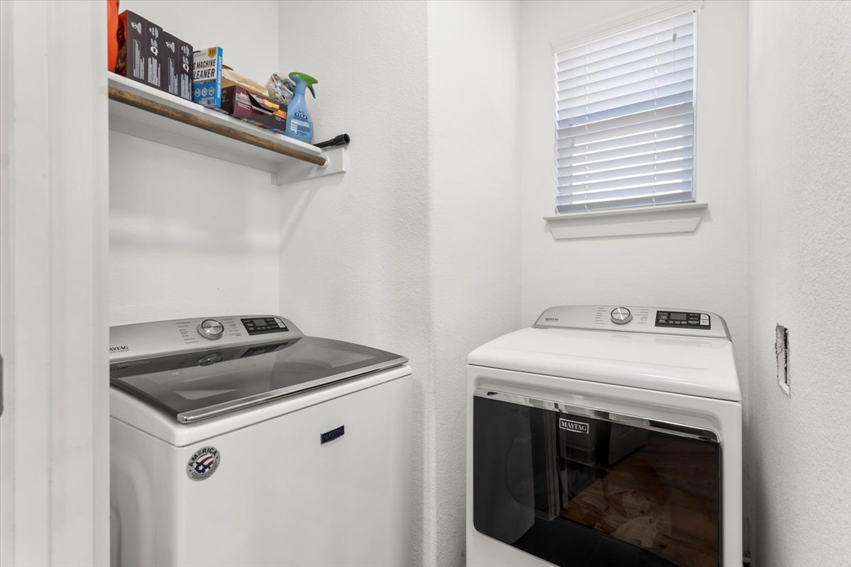 6912 Cardinal Bloom Loop Austin, TX 78744 - Photo 20 of 33 A dedicated utility space with contemporary laundry appliances and convenient shelving for essentials.