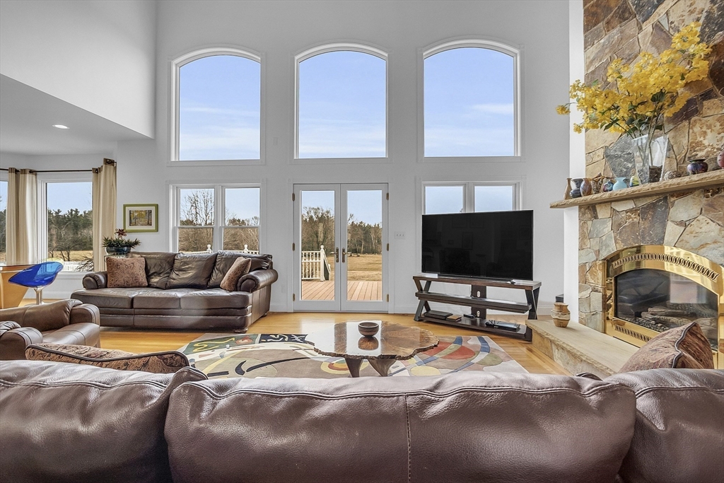 148 Houghton Road Princeton, MA 01541 - Photo 18 of 42 a living room with couches a flat screen tv and a large window with garden view