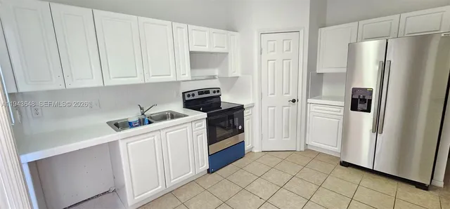 a kitchen with white cabinets and white appliances