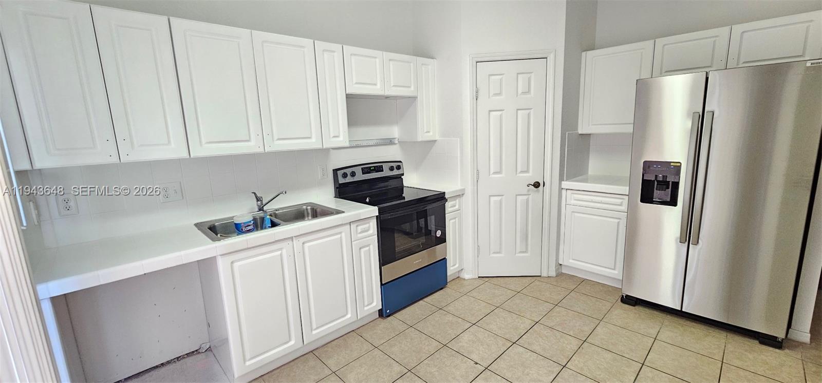 1941 Southeast 23rd Terrace, Unit 1941 Homestead, FL 33035 - Photo 2 of 7 a kitchen with white cabinets and white appliances