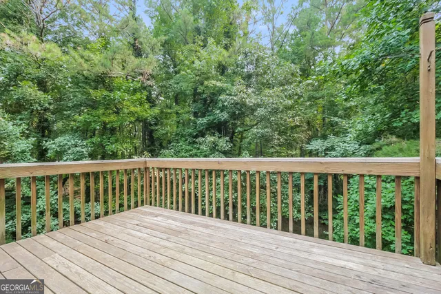 a view of a house with a yard and a large tree