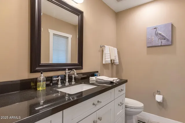 a bathroom with a granite countertop toilet a sink and shower