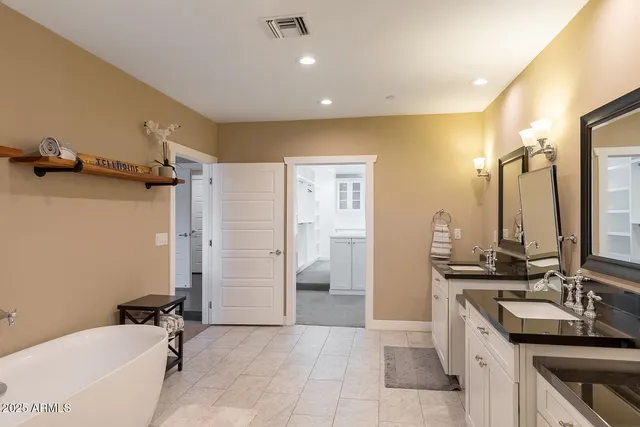 a bathroom with a double vanity sink a mirror and a bathtub