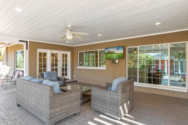 a bedroom with a large bed and a chandelier next to a window
