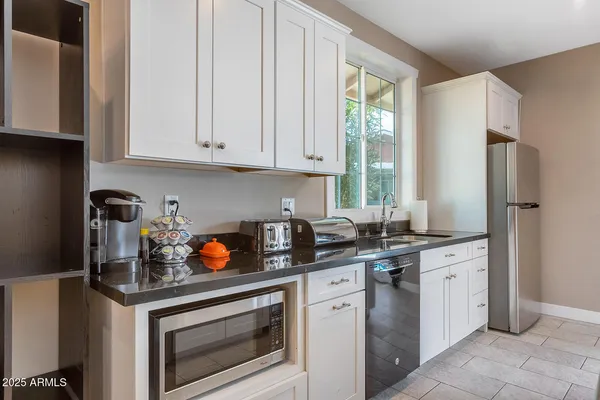 a view of a patio with a table and chairs under an umbrella with palm trees