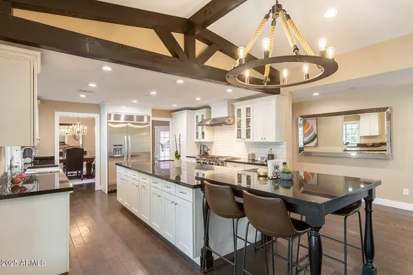 a large kitchen with granite countertop lots of counter space and a sink
