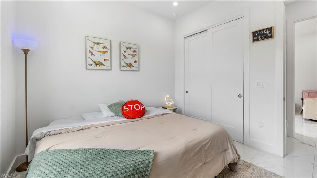 2998 52nd Street Southwest Naples, FL 34116 - Photo 18 of 44 Bedroom featuring a closet, recessed lighting, and light marble finish floors
