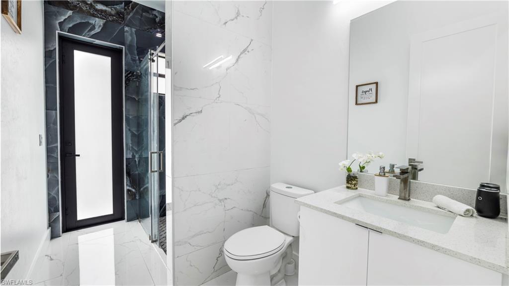 2998 52nd Street Southwest Naples, FL 34116 - Photo 23 of 44 Bathroom with vanity and a marble finish shower