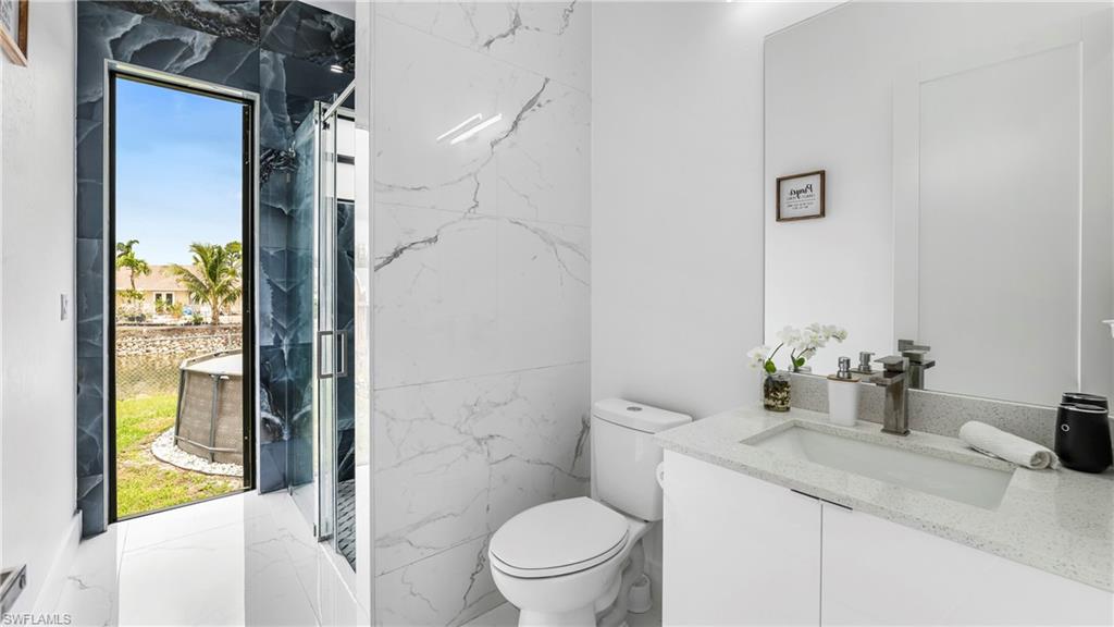 2998 52nd Street Southwest Naples, FL 34116 - Photo 24 of 44 Bathroom with vanity and a marble finish shower