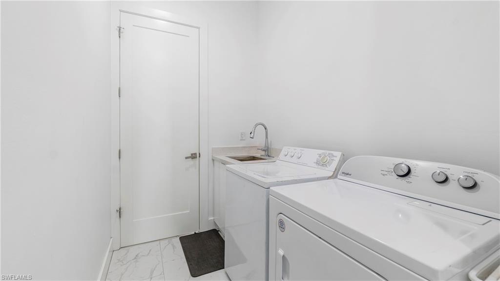 2998 52nd Street Southwest Naples, FL 34116 - Photo 29 of 44 Laundry area with light marble finish flooring and separate washer and dryer