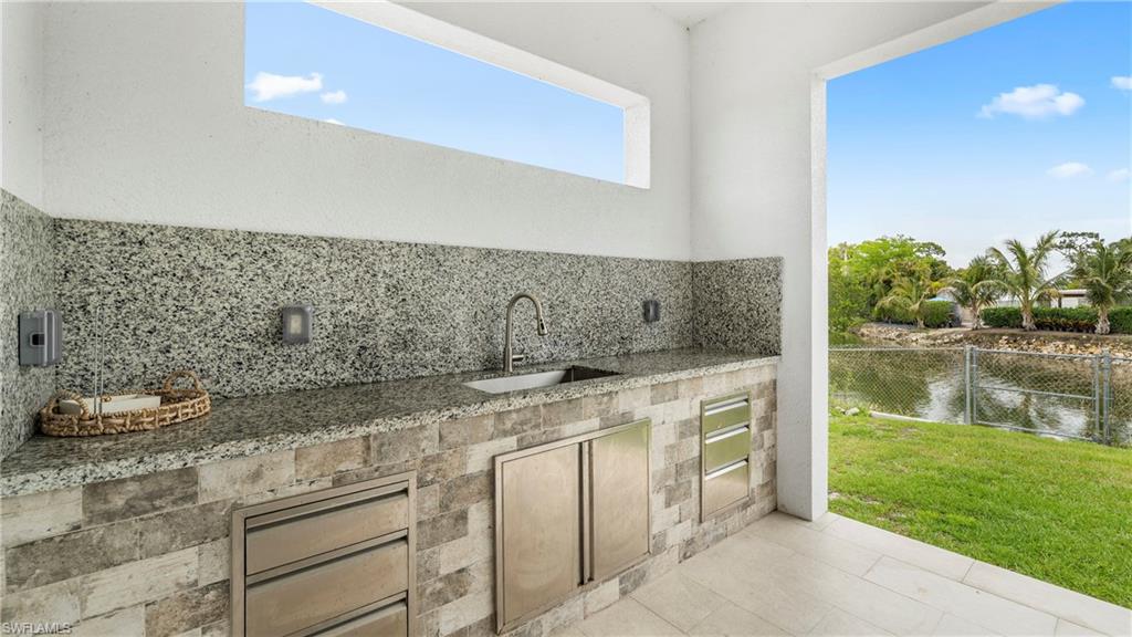 2998 52nd Street Southwest Naples, FL 34116 - Photo 30 of 44 View of patio / terrace featuring exterior kitchen and a water view