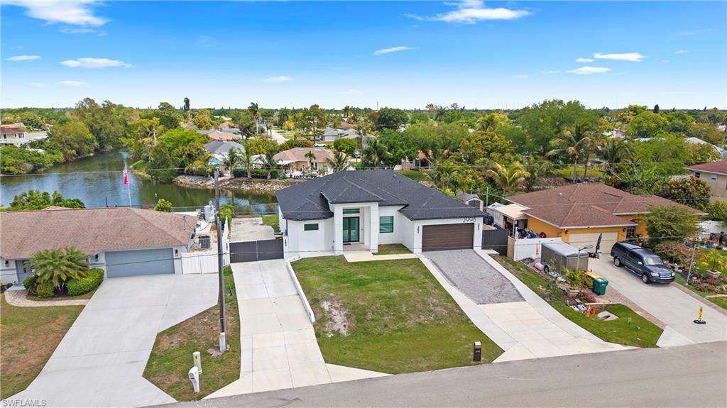 2998 52nd Street Southwest Naples, FL 34116 - Photo 37 of 44 Aerial perspective of suburban area featuring a tree filled landscape and a large body of water