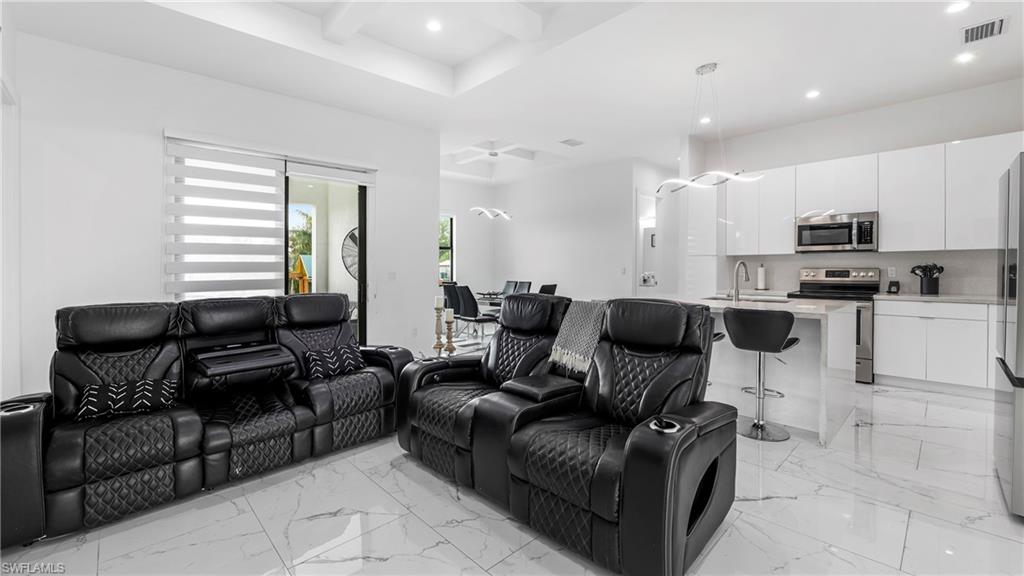 2998 52nd Street Southwest Naples, FL 34116 - Photo 7 of 44 Cinema with recessed lighting, coffered ceiling, light marble finish flooring, and a ceiling fan