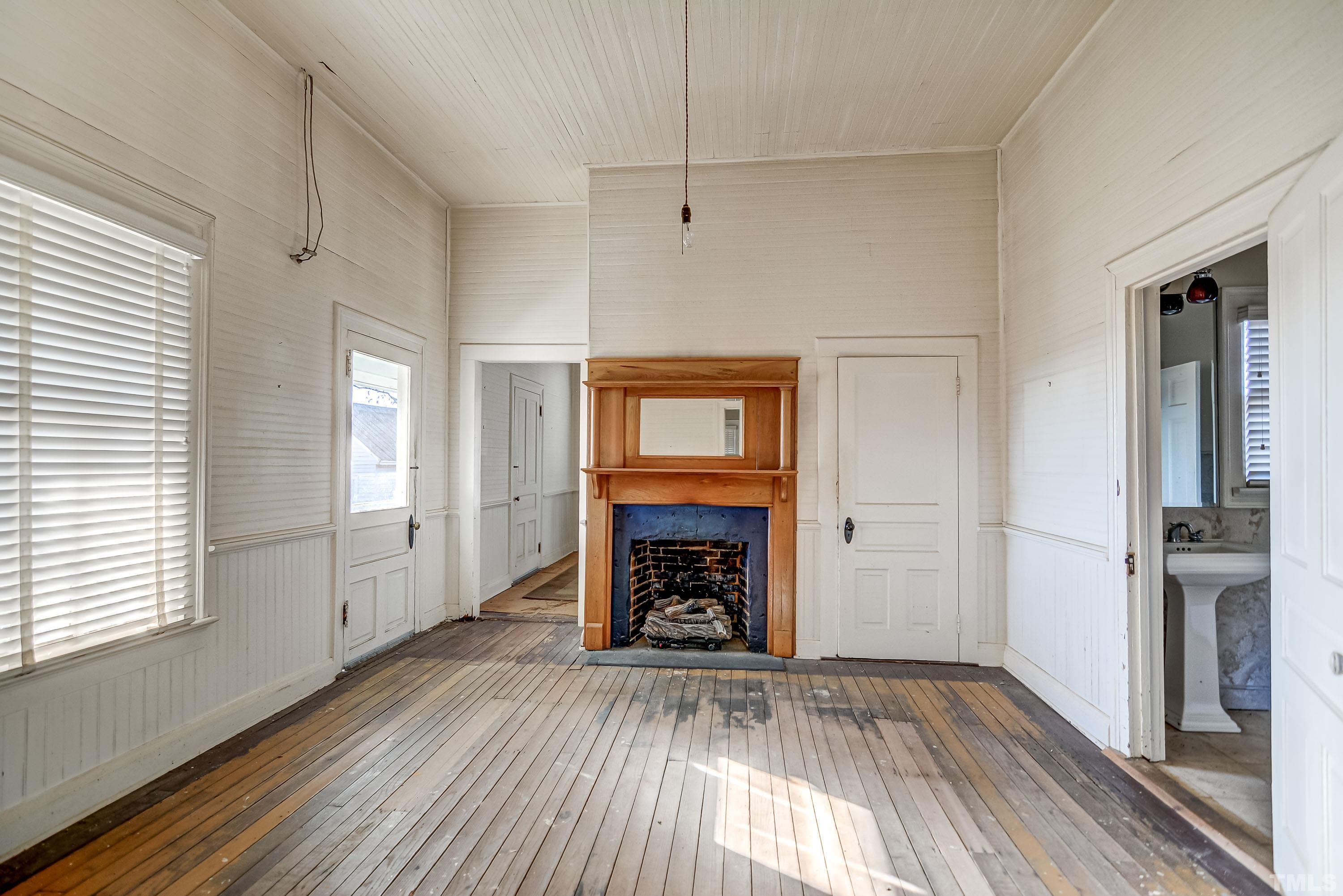 4740 Auburn Knightdale Road Raleigh, NC 27610 - Photo 16 of 23 an empty room with wooden floor a fireplace and windows