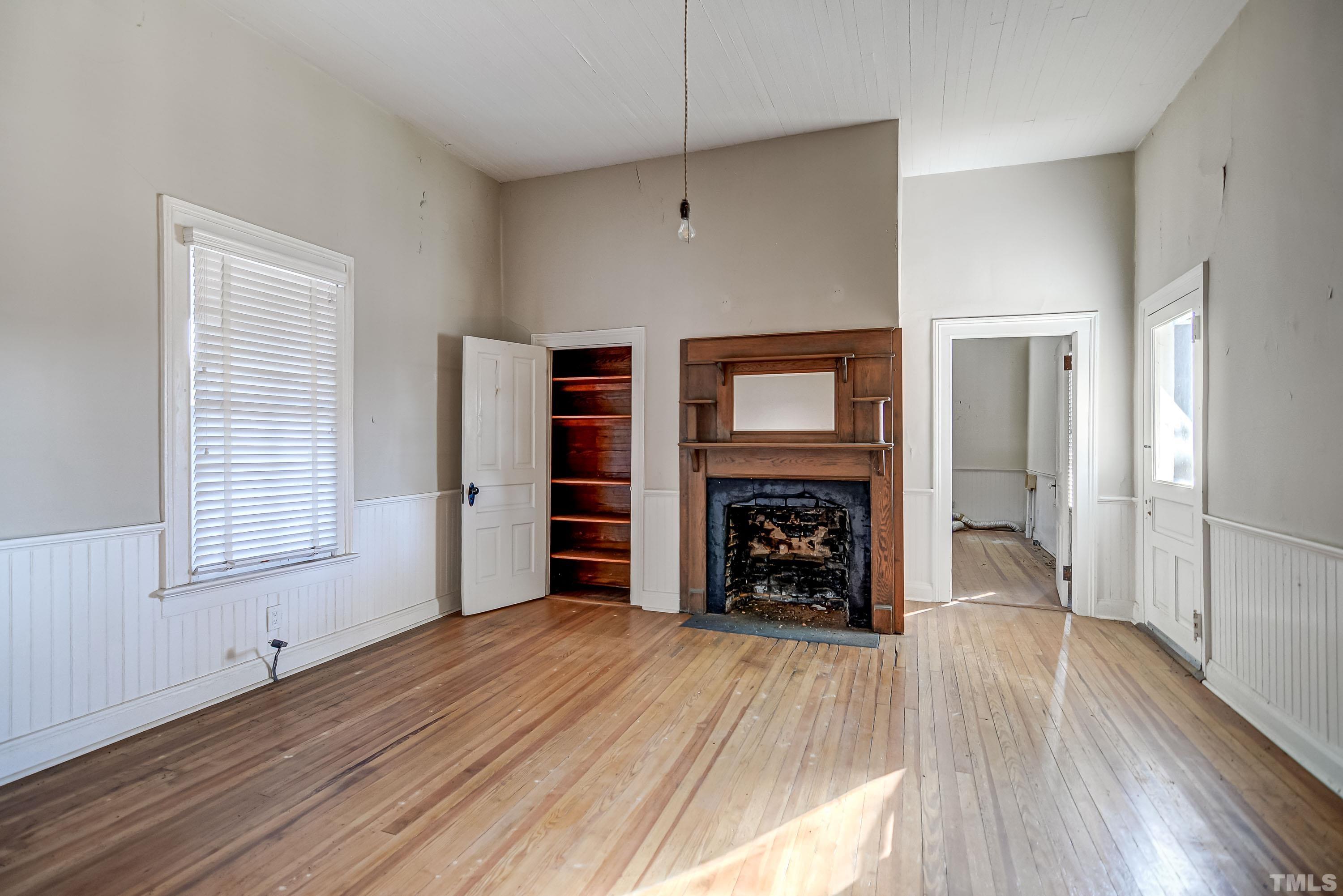 4740 Auburn Knightdale Road Raleigh, NC 27610 - Photo 19 of 23 a view of an empty room with wooden floor fireplace and a window