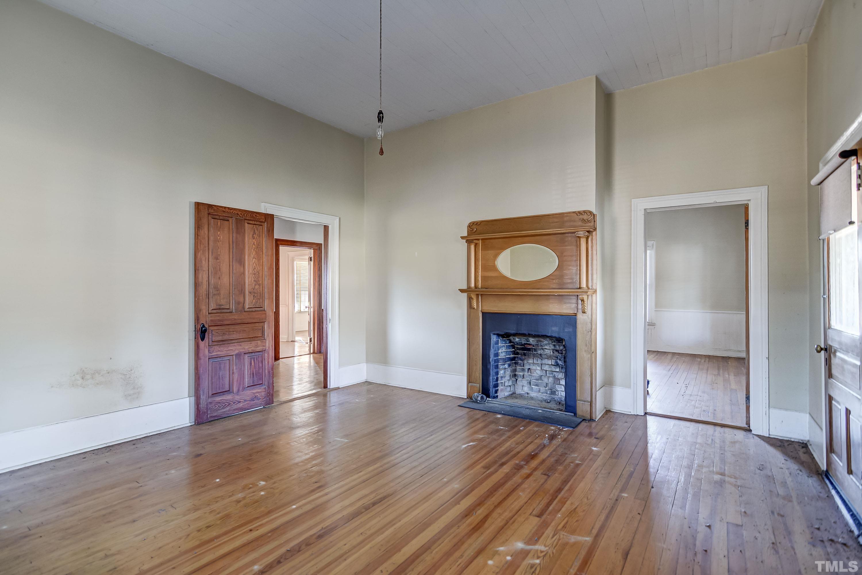 4740 Auburn Knightdale Road Raleigh, NC 27610 - Photo 20 of 23 an empty room with wooden floor a fireplace and entryway