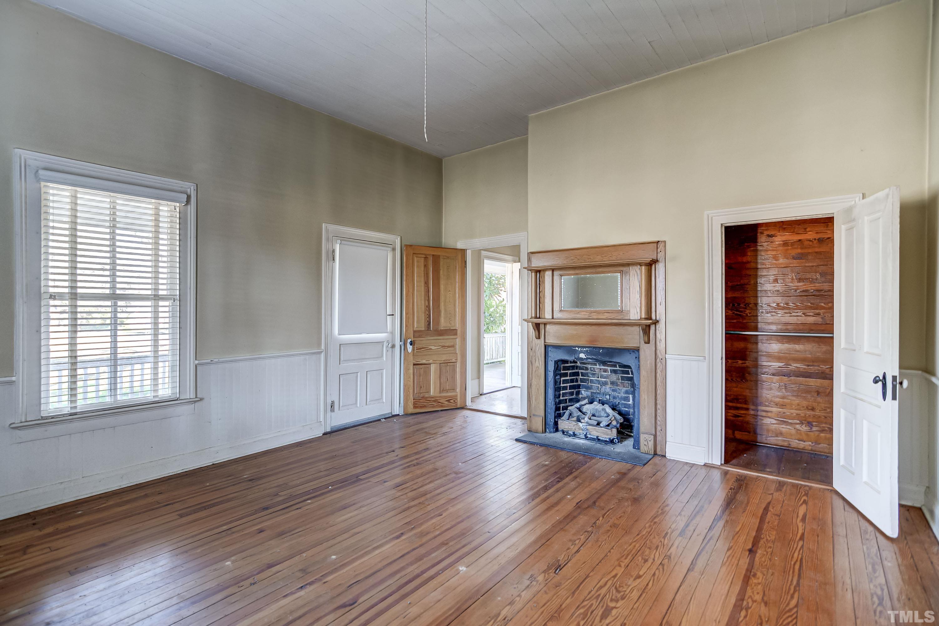 4740 Auburn Knightdale Road Raleigh, NC 27610 - Photo 22 of 23 an empty room with wooden floor fireplace and windows