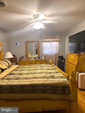 a spacious bedroom with a bed and a flat screen tv