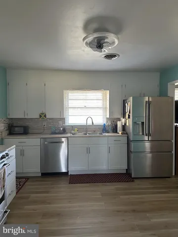 a kitchen with a refrigerator and white cabinets