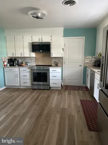 a kitchen with granite countertop a stove and a refrigerator