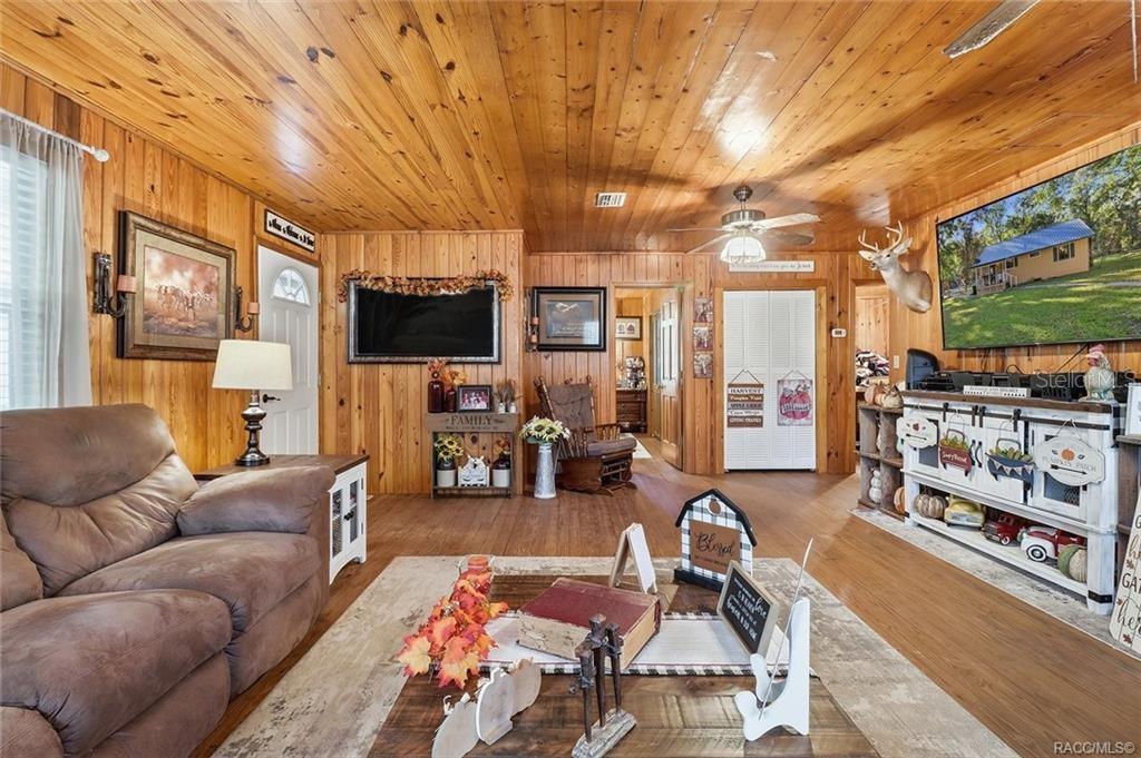 8110 Southwest 88th Lane Trenton, FL 32693 - Photo 9 of 29 a living room with furniture a flat screen tv and floor to ceiling window