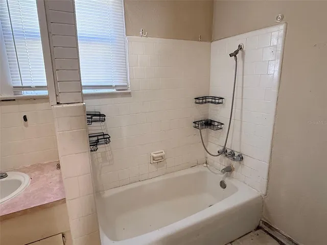 a bath tub sitting next to a bathroom sink