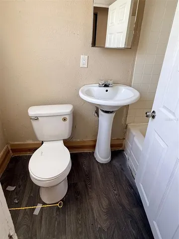 a bathroom with a toilet sink and mirror