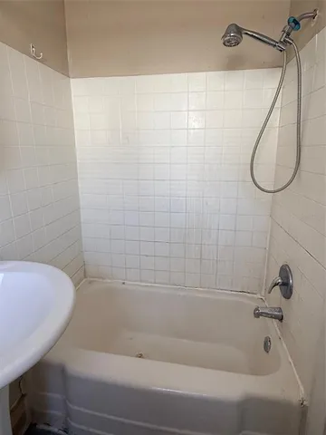 a bathroom with a bath tub with a shower